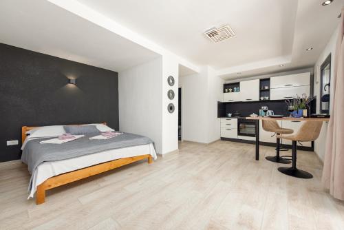 a bedroom with a bed and a desk and a kitchen at Unique Villa V with large pool in Benkovac