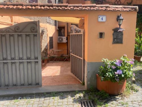 an entrance to a house with a gate and flowers at Blue Goose Apartment in Ronciglione