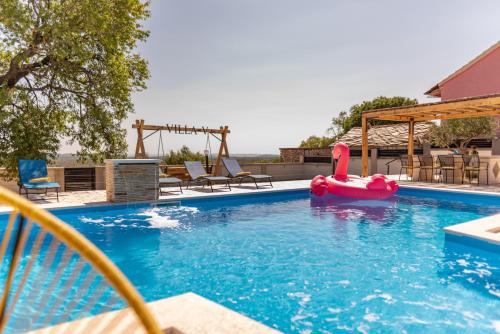 a swimming pool with a red inflatable raft in the water at Unique Villa V with large pool in Benkovac