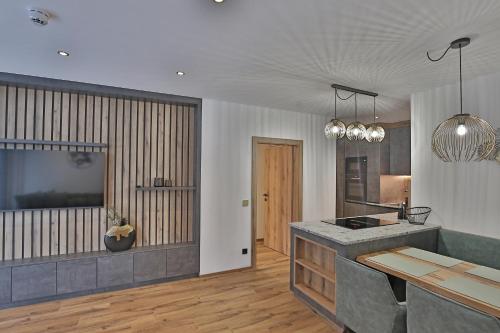 a kitchen with a counter and a table in a room at Das Goldjuwel - Luxury Apartments with private Spa in Goldegg