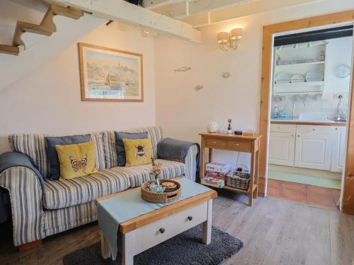a living room with a couch and a table at Cleve Cottage in Lyme Regis
