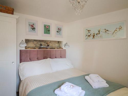 ein Schlafzimmer mit einem Bett mit zwei Handtüchern darauf in der Unterkunft Cleve Cottage in Lyme Regis