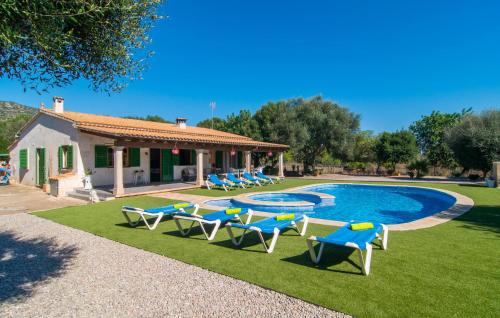 a yard with chairs and a pool with a house at Sa Sargantana in Llucmajor