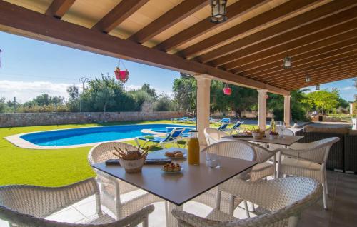 a patio with tables and chairs and a swimming pool at Sa Sargantana in Llucmajor
