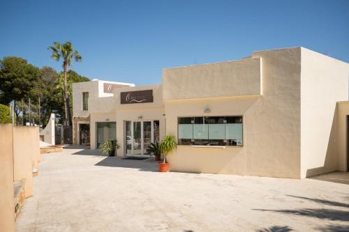 a building with a palm tree in front of it at Apartamentos Azul Playa in Cala d´Or