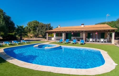 a swimming pool in a yard with chairs and a house at Sa Sargantana in Llucmajor