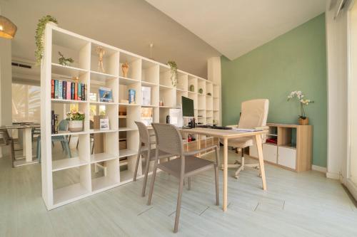 a home office with a desk and chairs and bookshelves at Apartamentos Azul Playa in Cala d´Or