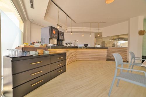 a kitchen with a counter and a table and chairs at Apartamentos Azul Playa in Cala d´Or