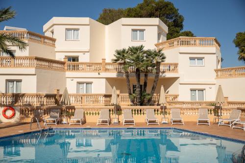 a hotel with a swimming pool in front of a building at Apartamentos Azul Playa in Cala d´Or