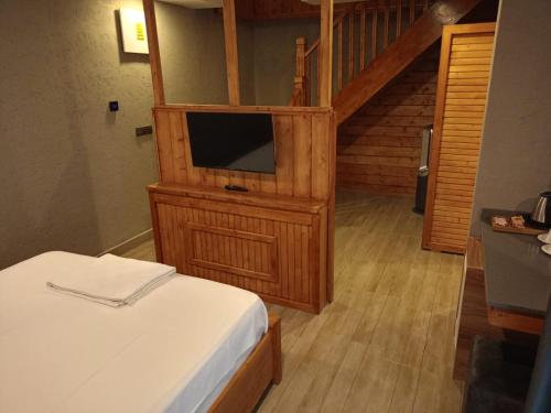 a bedroom with a bed and a tv on a wooden cabinet at Ber Mai İnci Hotel Antalya in Antalya