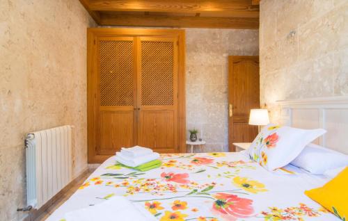 a bedroom with a bed with a floral bedspread at Sa Sargantana in Llucmajor