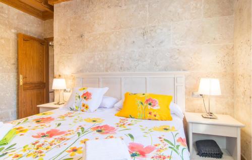 a bedroom with a bed with a floral bedspread and two lamps at Sa Sargantana in Llucmajor