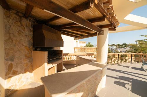 a patio with a stone fireplace on a deck at Apartamentos Azul Playa in Cala d´Or