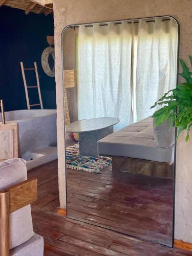 a mirror in a room with a bed and a table at Hotel & Spa La Ferme El Dar in Marrakech