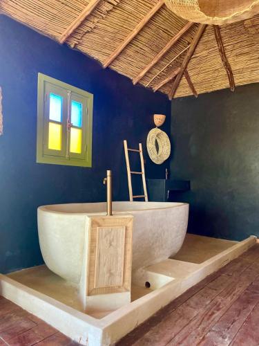 a bathroom with a white tub in a blue wall at Hotel & Spa La Ferme El Dar in Marrakech