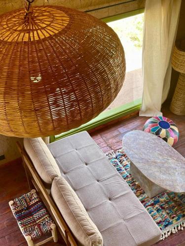 a room with a couch and a table and a window at Hotel & Spa La Ferme El Dar in Marrakech