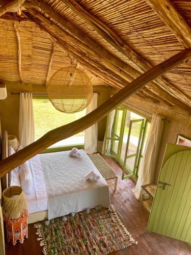 a bedroom with a bed and a large window at Hotel & Spa La Ferme El Dar in Marrakech