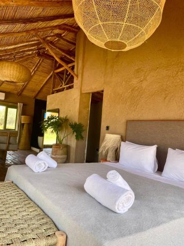 a bedroom with two beds with towels on them at Hotel & Spa La Ferme El Dar in Marrakech