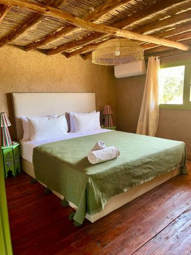 a bedroom with a bed with a towel on it at Hotel & Spa La Ferme El Dar in Marrakech