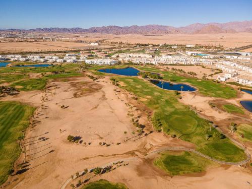 an aerial view of a golf course in the desert at Pickalbatros Golf Luxury Suites - All Inclusive in Sharm El Sheikh