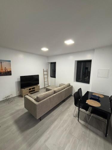 a living room with a couch and a flat screen tv at Vila Ramos I in Funchal