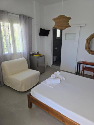 a bedroom with a white bed and a chair at Oasis in Kamarai