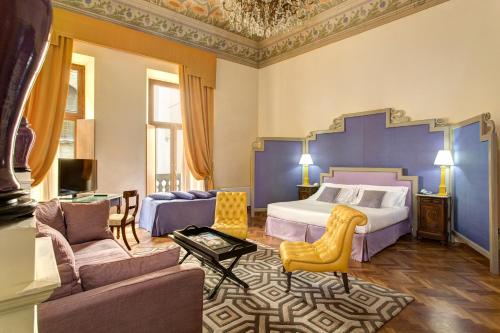 a bedroom with a king sized bed and a living room at Grand Hotel Cavour in Florence