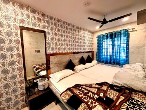 a bedroom with two beds and a mirror at Hotel Khushhal Manzil in Ajmer