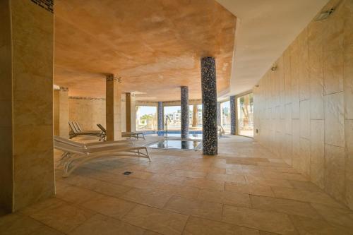 a room with a bench and pillars in a building at Apartamentos Azul Playa in Cala d´Or