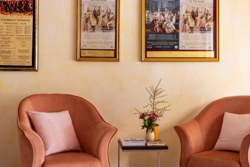 two chairs in a waiting room with posters on the wall at Hotel & Residence Venezia 2000 in Venice-Lido