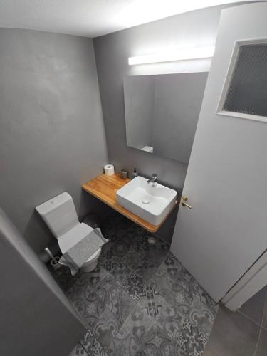 a bathroom with a sink and a toilet and a mirror at Oasis in Kamarai