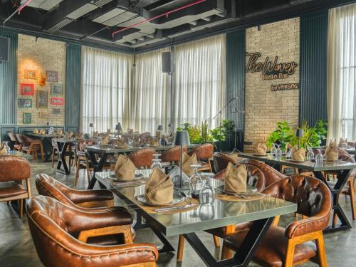 a dining room with tables and leather chairs at Hyksos Hotel in Erbil