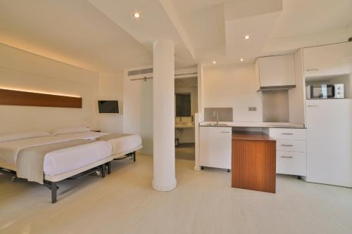 a bedroom with two beds and a kitchen at Apartamentos Azul Playa in Cala d´Or