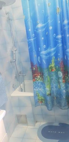 a bathroom with a shower curtain with an aquarium at Guest House Cinderella in Herceg-Novi