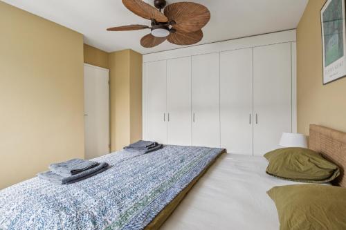 a bedroom with a bed with a ceiling fan at UP&GREAT Apartments - Stylish City Living in Zürich