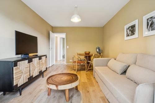 a living room with a couch and a tv at UP&GREAT Apartments - Stylish City Living in Zürich