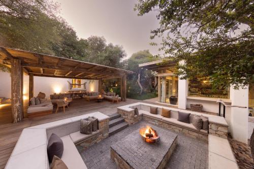 an outdoor patio with a fire pit and a fireplace at Kapama Karula in Kapama Private Game Reserve