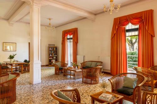 a living room with orange curtains and chairs at Hotel & Residence Venezia 2000 in Venice-Lido