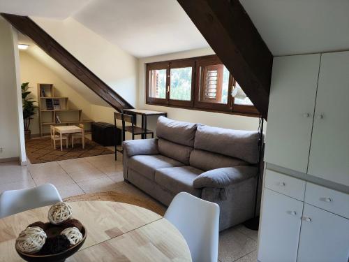 a living room with a couch and a table at Apartamento ático Belabarce in Isaba