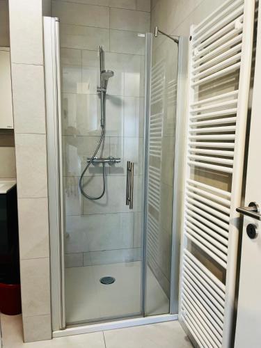 a shower with a glass door in a bathroom at Cozy Cloche Nest - Studio in Luxembourg
