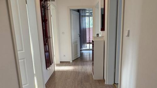 a hallway with white walls and wooden floors and a door at Haus am Röblinsee - Ferienwohnungen in Fürstenberg in Fürstenberg-Havel