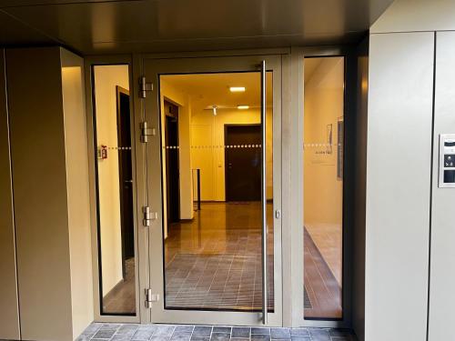 an entrance to a building with sliding glass doors at Cozy Cloche Nest - Studio in Luxembourg