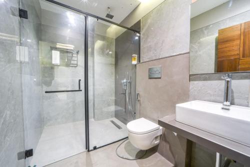 a bathroom with a shower and a toilet and a sink at Hotel Devgiri Inn and Restaurant in Sangli