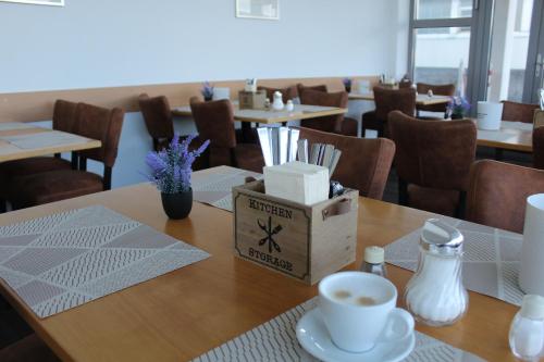 a table with a cup of coffee and a box on it at Hotel am Südtor in Backnang