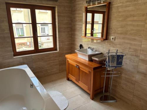 a bathroom with a tub and a sink and a mirror at Nicole in Hartau
