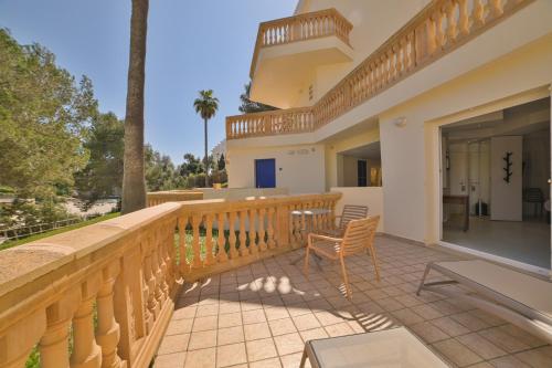 a balcony of a house with a table and chairs at Apartamentos Azul Playa in Cala d´Or