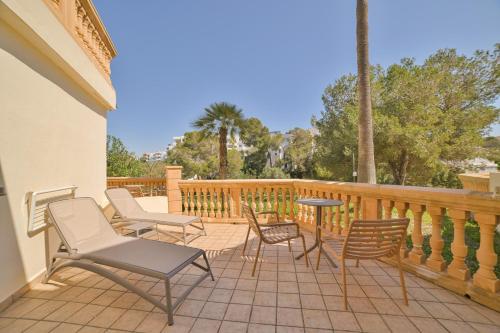 a patio with chairs and a table on a deck at Apartamentos Azul Playa in Cala d´Or