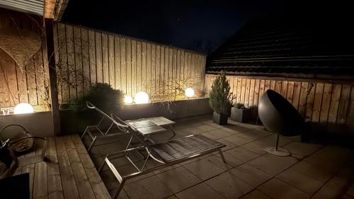 a patio with a chair and a table and lights at Hotel Krone Sihlbrugg in Sihlbrugg Dorf