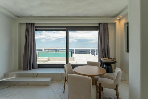 a living room with a table and chairs and a large window at Numi Suites in Mýkonos City