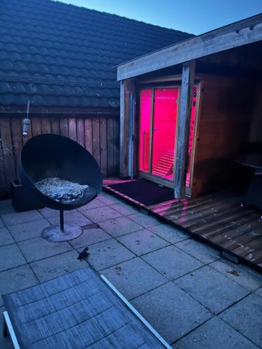 a black chair sitting on a patio with a red light at Hotel Krone Sihlbrugg in Sihlbrugg Dorf